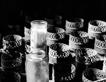 Close-up of containers and candle in glass jar on table