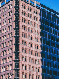 Low angle view of modern building against blue sky