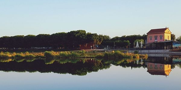 Scenic view of lake by building against clear sky