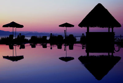 Silhouette parasols at poolside during sunset