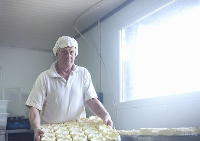 Expertise holding cheese tray while standing at dairy
