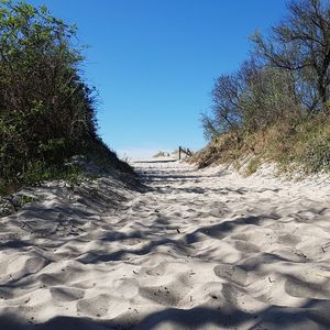 Scenic view of beach against clear blue sky