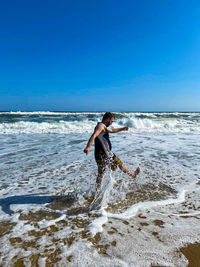 Man surfing on beach against sky