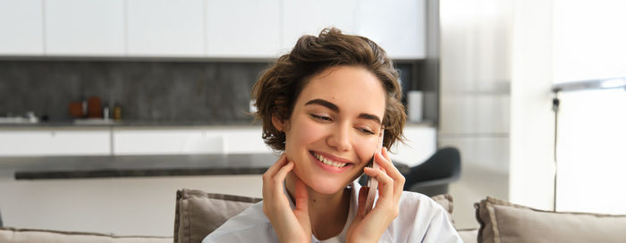 Young woman using mobile phone at home