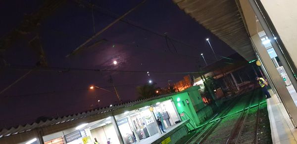 Low angle view of illuminated railroad station at night