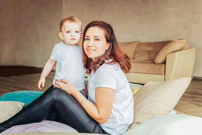 Portrait of smiling mother with daughter at home