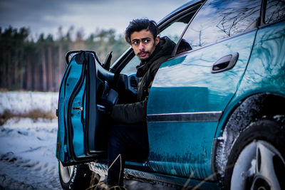 Portrait of young man sitting in car