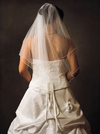 Rear view of bride against black background
