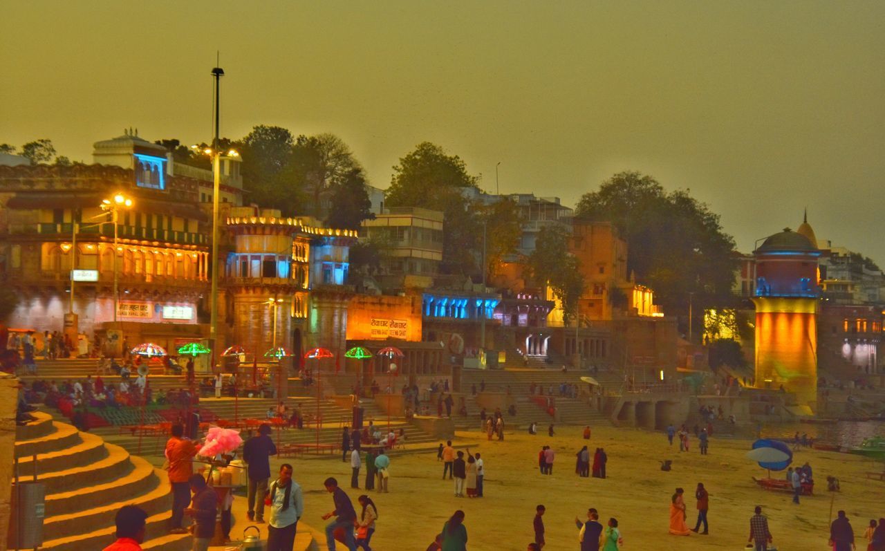 PEOPLE ON STREET AGAINST ILLUMINATED BUILDINGS IN CITY