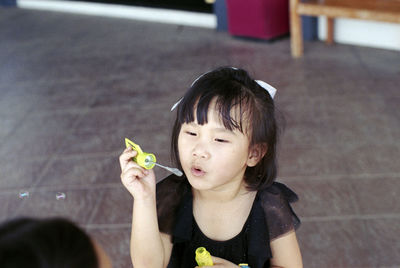 High angle view of girl blowing bubble