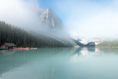 Scenic view of lake by trees against sky