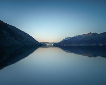 Scenic view of lake and mountains against clear sky