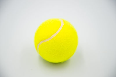 Close-up of yellow ball on white background
