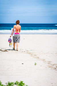 Rear view of woman walking on beach