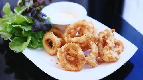 Close-up of served fried calamari fish in plate