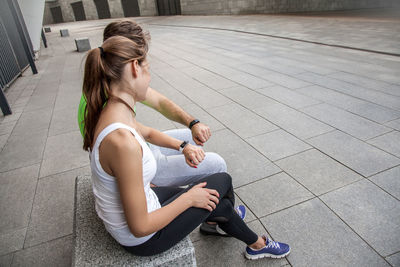 High angle view of young woman sitting outdoors