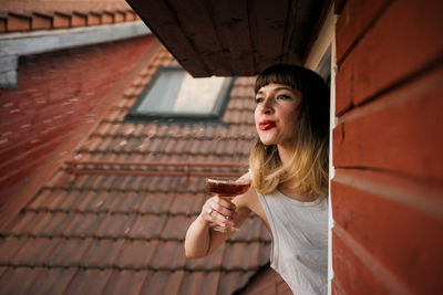 Portrait of a smiling young woman drinking water