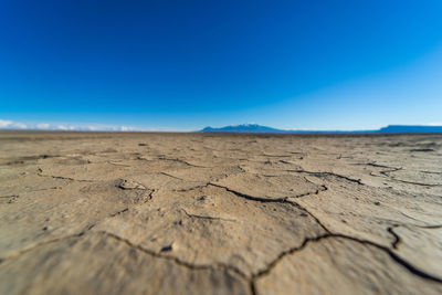 Surface level of desert against clear blue sky