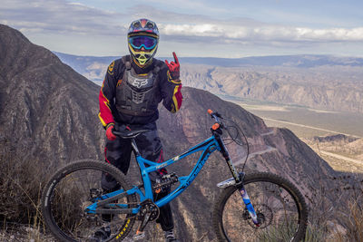 Man riding motorcycle on mountain against sky