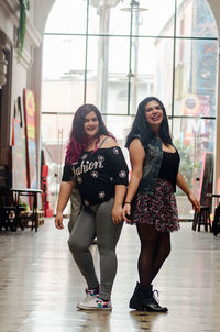 Full length portrait of smiling young woman