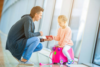 Full length of father holding passport at airport