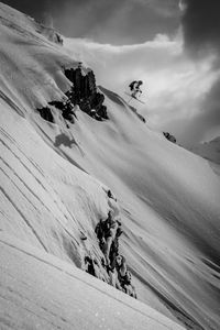 Side view of a skier jumping over snow covered slope