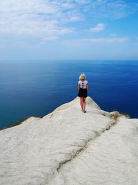 Rear view of woman looking at sea against sky