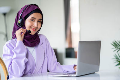 Young woman using laptop at table