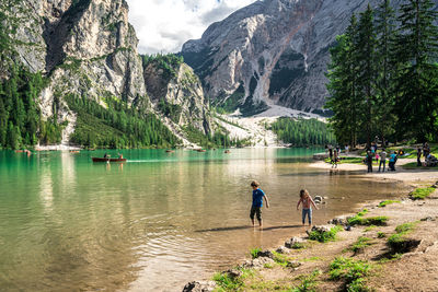 Rear view of people walking at lakeshore