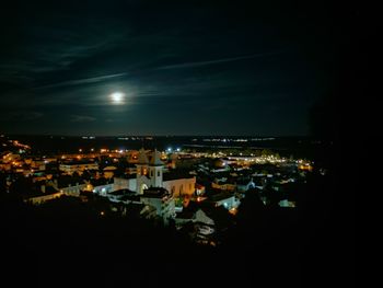 High angle view of illuminated cityscape against sky at night