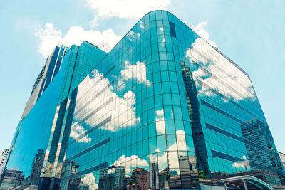 Low angle view of modern glass building against sky