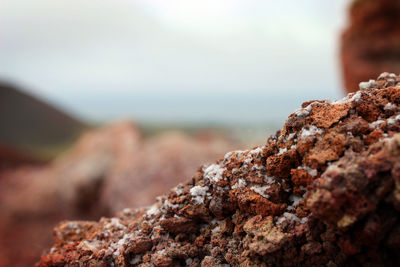 Close-up of rocks on rock against sky