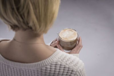 Rear view of woman holding coffee cup