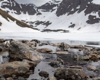 Scenic view of sea by snowcapped mountains