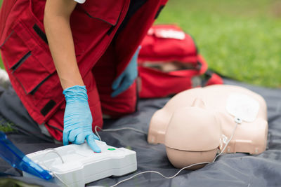 Midsection of paramedic practicing cpr on dummy