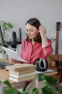 Young woman using mobile phone while sitting on table