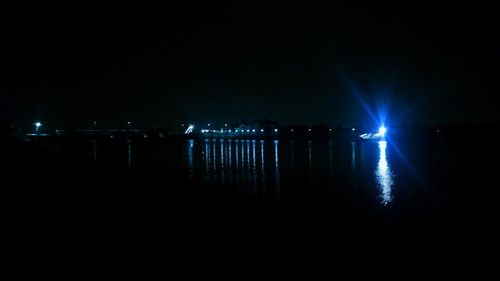 Scenic view of illuminated lake against sky at night