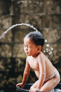 Full length of shirtless boy in water