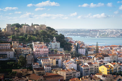 High angle view of townscape by sea against sky