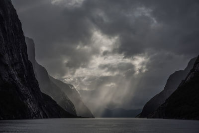 Scenic view of lysefjord by mountain against sky