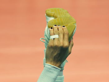 Cropped image of woman touching shoe