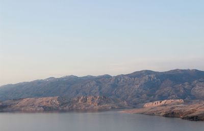 Scenic view of sea and mountains against clear sky