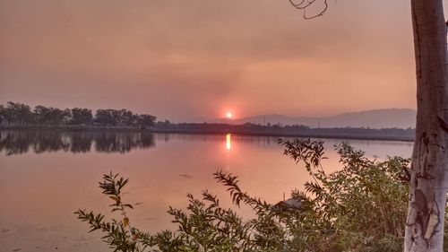 Scenic view of lake against sky during sunset