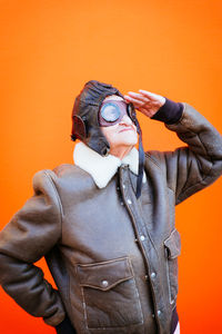 Senior woman wearing glasses against orange background