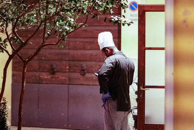 Rear view of man standing against building