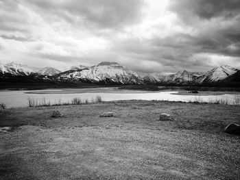 Scenic view of lake by snowcapped mountains against sky