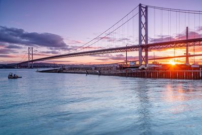 View of bridge over river at sunset