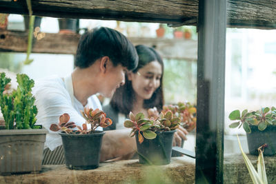 Couple looking at potted plants window