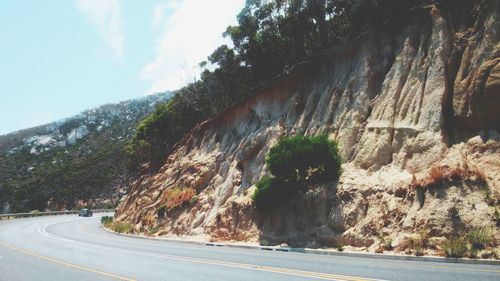 Road amidst trees against sky