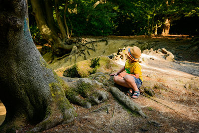 Full length of man sitting on rock